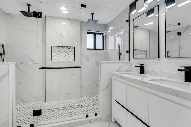 bathroom featuring marble finish floor, a sink, a marble finish shower, and double vanity