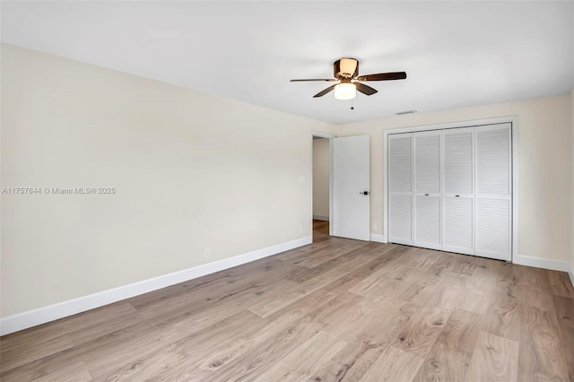 unfurnished bedroom with a ceiling fan, a closet, light wood finished floors, and baseboards