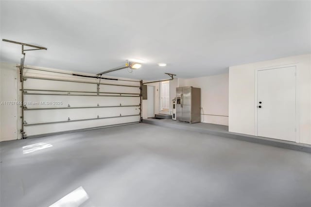 garage featuring a garage door opener and stainless steel fridge