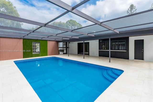 outdoor pool with glass enclosure and a patio area