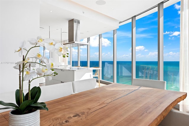 dining room with a water view and expansive windows