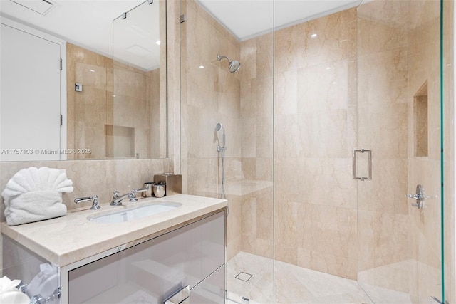 bathroom featuring a stall shower, backsplash, vanity, and tile walls