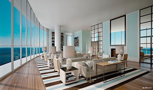 living room with a water view, hardwood / wood-style flooring, and floor to ceiling windows