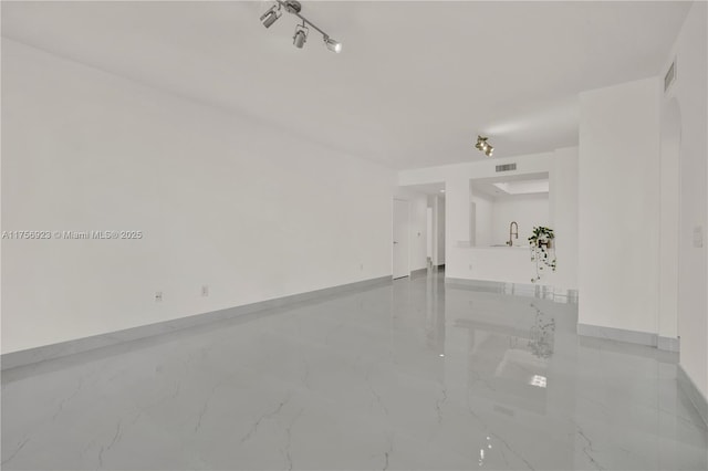 interior space featuring marble finish floor, baseboards, visible vents, and a sink