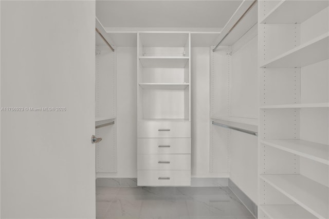 walk in closet featuring marble finish floor