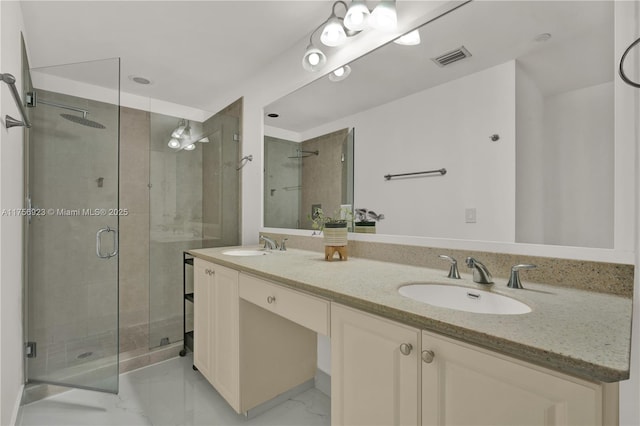 full bathroom with a stall shower, marble finish floor, and a sink