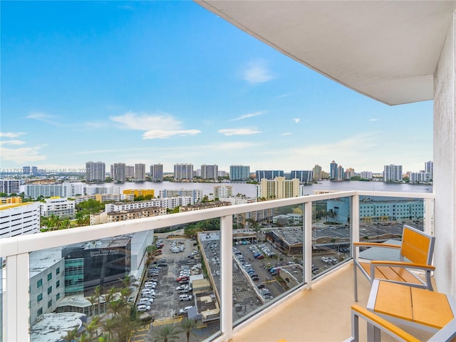 balcony with a water view and a view of city