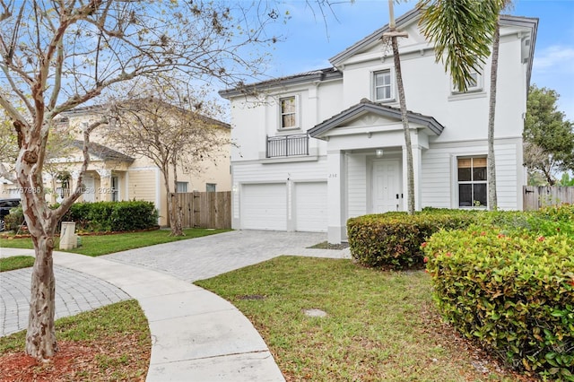 view of front facade with a garage, decorative driveway, fence, and stucco siding