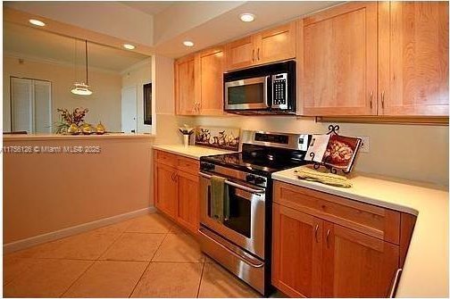 kitchen featuring stainless steel appliances, light countertops, light tile patterned flooring, and recessed lighting