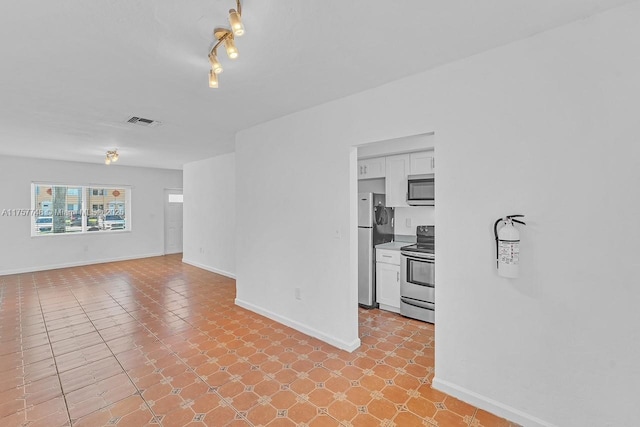 empty room featuring baseboards and visible vents