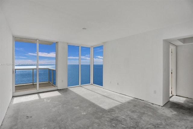 unfurnished room featuring concrete flooring and a water view