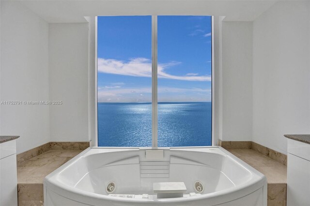 bathroom with a water view and a tub with jets