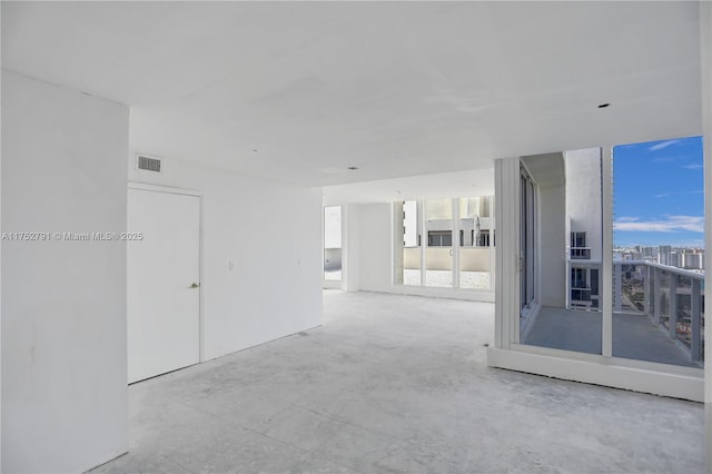 empty room featuring visible vents and a city view