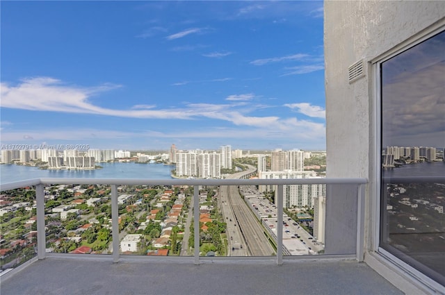 balcony with a view of city, a water view, and visible vents