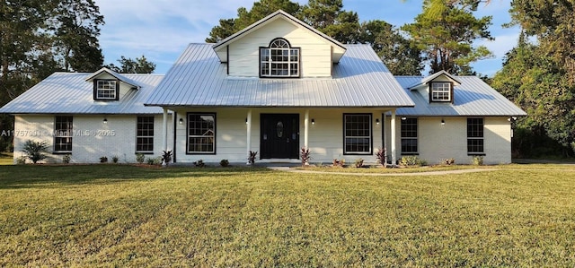 view of front of house featuring brick siding, metal roof, and a front lawn