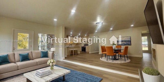 living room featuring baseboards, wood finished floors, and recessed lighting