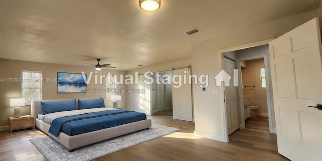 bedroom featuring baseboards, visible vents, a ceiling fan, connected bathroom, and wood finished floors