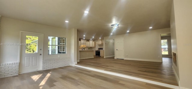 unfurnished living room featuring light wood-style floors, baseboards, and recessed lighting