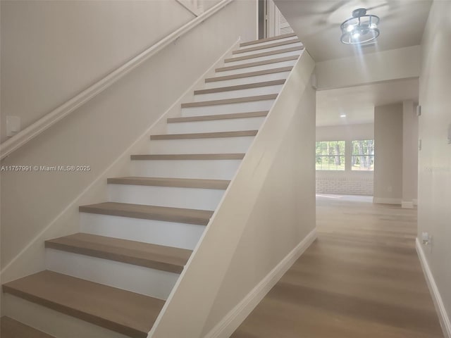 stairs with baseboards and wood finished floors