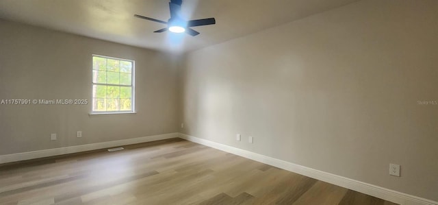 empty room featuring a ceiling fan, baseboards, and wood finished floors