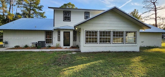 view of front of home with metal roof, a front lawn, brick siding, and central air condition unit