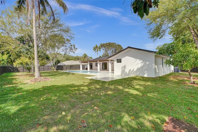 rear view of house featuring a fenced in pool, a yard, stucco siding, a patio area, and a fenced backyard