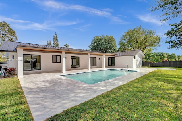 back of property featuring a standing seam roof, fence, a yard, a patio area, and stucco siding