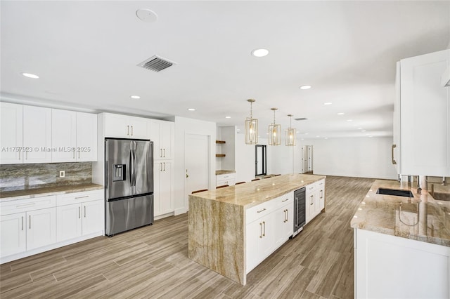 kitchen with wine cooler, visible vents, light wood-type flooring, backsplash, and stainless steel fridge with ice dispenser