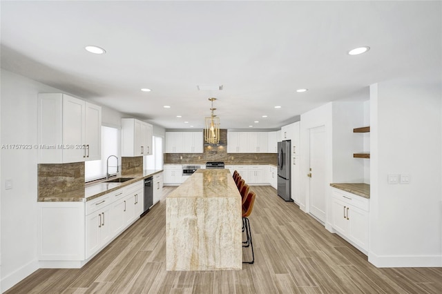 kitchen featuring stainless steel appliances, wood tiled floor, a sink, and backsplash