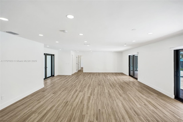 unfurnished room with light wood finished floors, visible vents, and recessed lighting