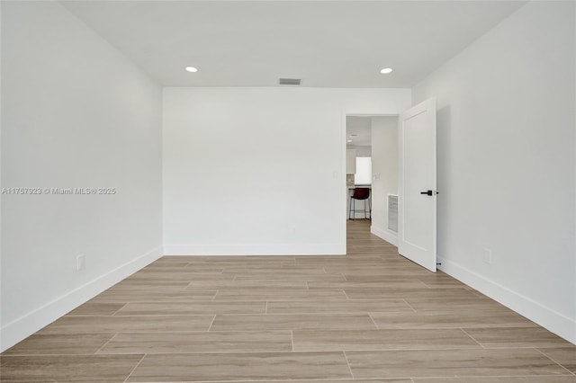 unfurnished room with wood tiled floor, baseboards, and recessed lighting