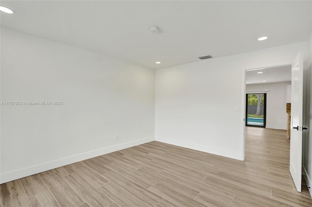 empty room with recessed lighting, visible vents, light wood-style flooring, and baseboards