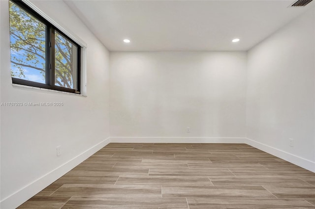 unfurnished room with light wood-style flooring, visible vents, baseboards, and recessed lighting