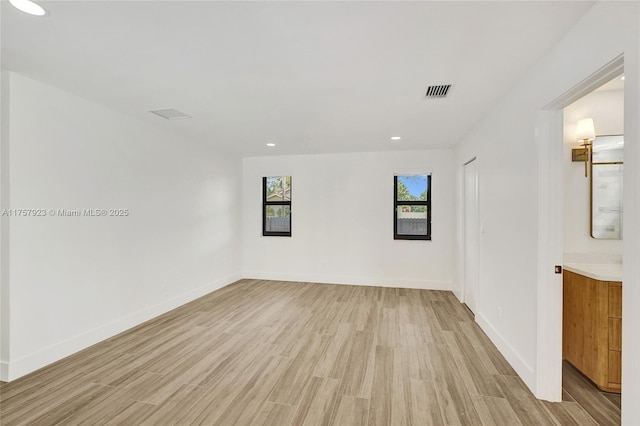 empty room featuring recessed lighting, visible vents, light wood-style flooring, and baseboards