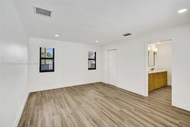 unfurnished room featuring light wood finished floors, baseboards, and visible vents