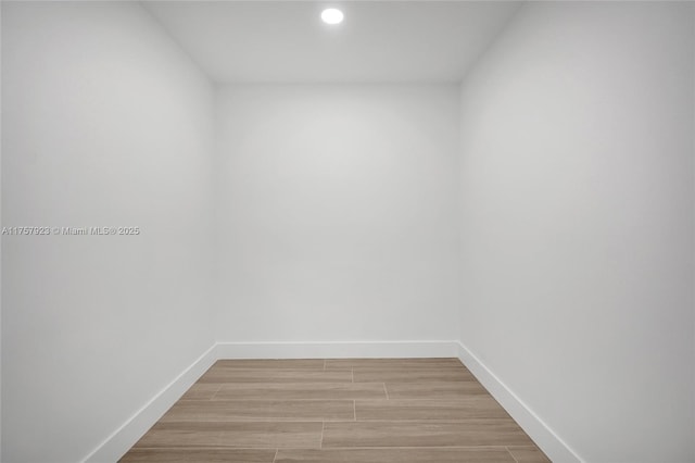 unfurnished room featuring wood tiled floor, baseboards, and recessed lighting