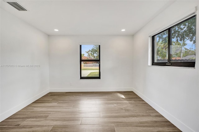 spare room featuring baseboards, visible vents, wood finished floors, and recessed lighting