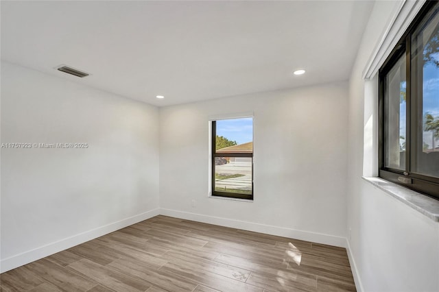 spare room with recessed lighting, visible vents, baseboards, and wood finished floors