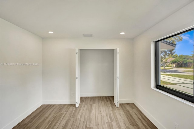 unfurnished room with recessed lighting, wood finished floors, and baseboards