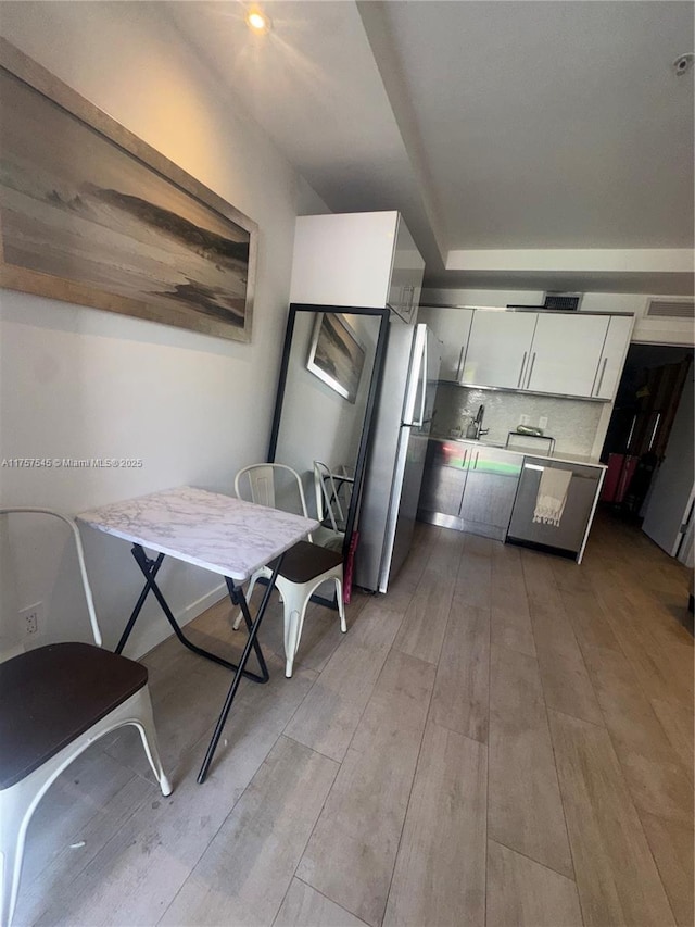 dining space with wood finished floors and visible vents