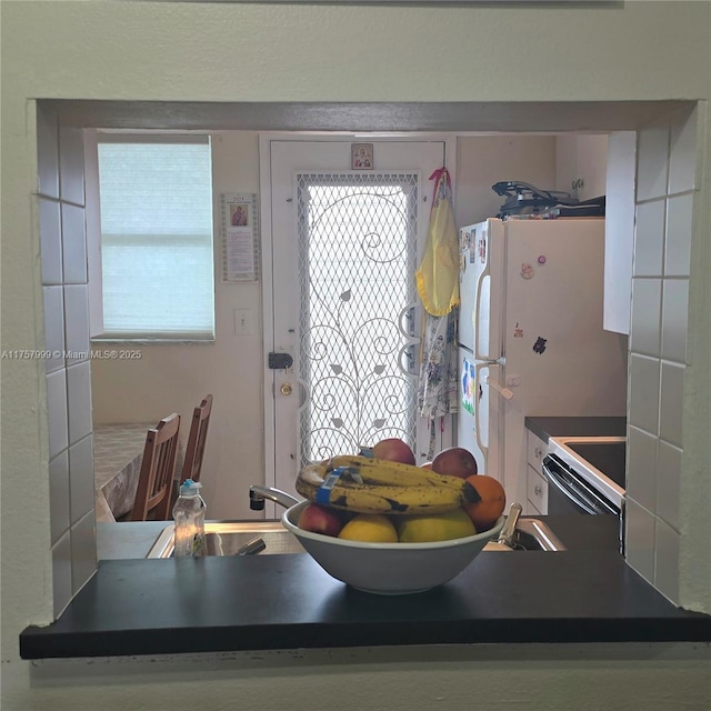 kitchen with freestanding refrigerator, electric stove, and dark countertops