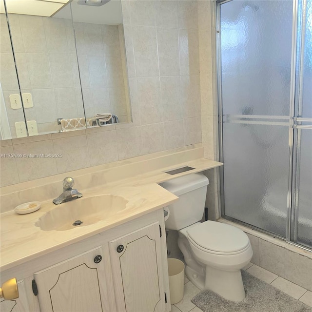 full bathroom with tile walls, tasteful backsplash, toilet, an enclosed shower, and tile patterned flooring