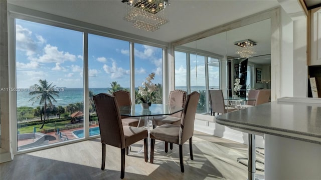 sunroom with a water view and a notable chandelier