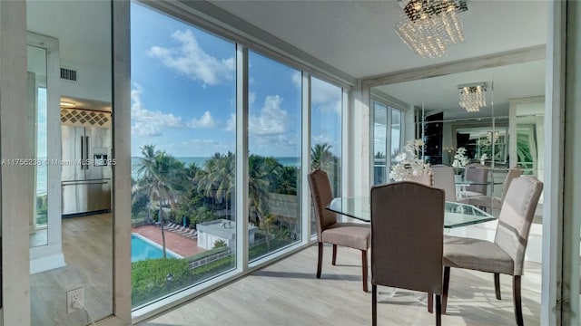 sunroom / solarium featuring a chandelier and visible vents