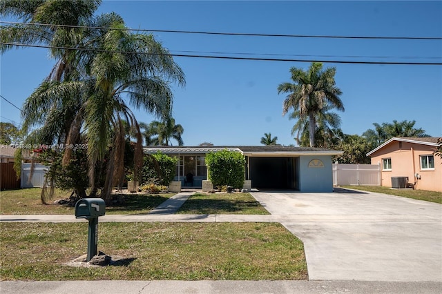 view of front facade with a front yard, driveway, fence, and central air condition unit