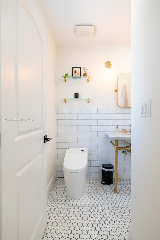 bathroom with tile walls, toilet, and tile patterned floors