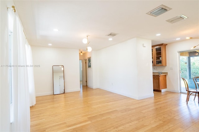 unfurnished room featuring light wood-style floors, baseboards, visible vents, and recessed lighting