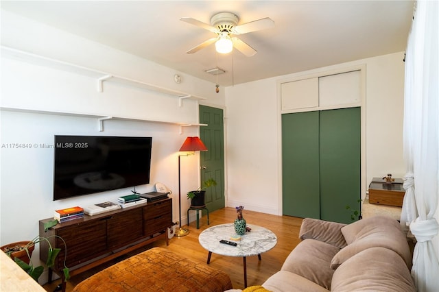 living area featuring light wood-style floors, visible vents, and a ceiling fan