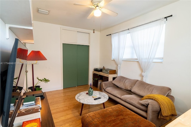 living area with a ceiling fan, visible vents, and light wood-style flooring