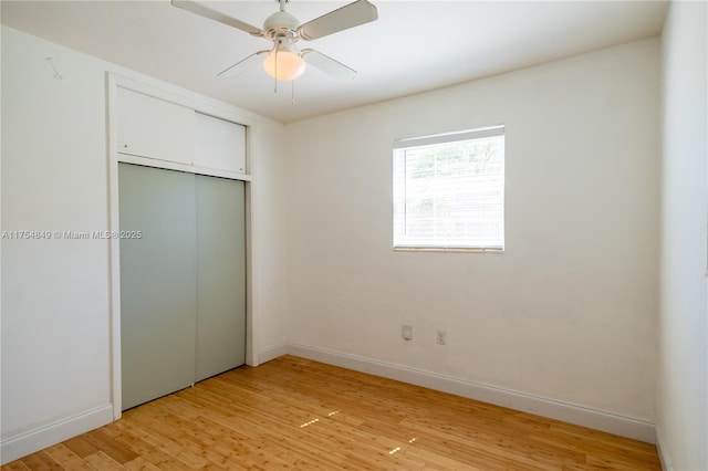 unfurnished bedroom featuring light wood-style floors, a ceiling fan, baseboards, and a closet